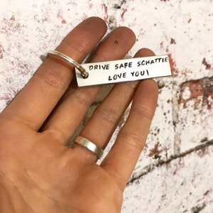 May include: Silver keyring with the text "Drive Safe Schattie Love You!" engraved on it.
