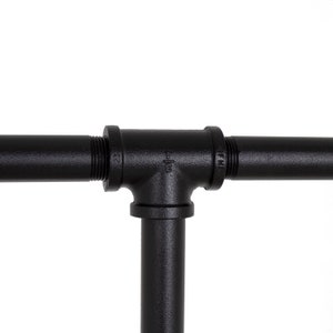 K&ouml;nnte beinhalten: Schwarzes Metallrohrfitting in T-Form. Das Rohr ist an beiden Enden Gewindef&ouml;rmig und hat die W&ouml;rter "Self" und "FM" auf der Seite eingepr&auml;gt.