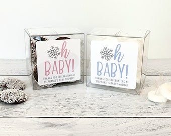 May include: Two clear plastic boxes filled with candy, each with a white square label that says "Oh Baby!" with a snowflake and the letter "h" in pink and blue. The text below says "Thanks for celebrating at Stephanie's Baby Shower!"