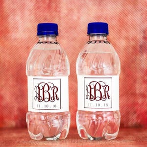 May include: Two clear plastic water bottles with white labels. The labels have a burgundy monogram and the date "11.10.18".