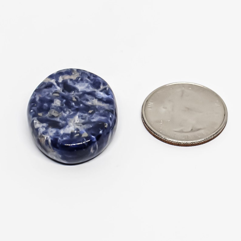 Pode incluir: Uma pedra natural redonda, polida, azul e branca, aproximadamente do tamanho de uma moeda de 25 centavos de d&oacute;lar americano.