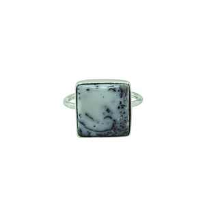 May include: A silver ring featuring a square-shaped white stone with dark, dendritic, fern-like inclusions. The stone is set in a smooth, polished silver bezel with a simple, thin, rounded silver band extending from the sides of the setting.