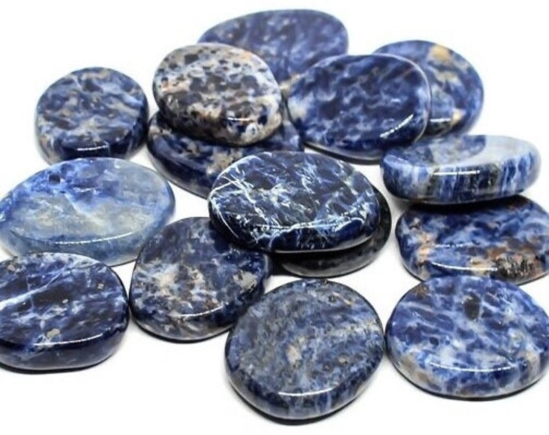 May include: A collection of smooth, oval-shaped blue and white stones. The stones have a variety of patterns and textures. The stones are arranged in a pile on a white surface.
