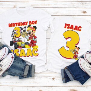 Puede incluir: Dos camisetas blancas con un tema de carreras de Mickey Mouse. Una camiseta dice "Birthday Boy 3 Isaac" y la otra "Isaac 3".