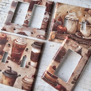 May include: Set of four decorative light switch covers featuring a coffee and dessert theme. Each cover has a different design with images of coffee cups, pastries, and text like "Tivoli" and "Voyage".