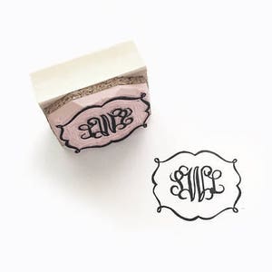 Może przedstawiać: Różowa gumowa pieczątka z czarną ozdobną obwódką i literami "SWB" w fantazyjnym skrypcie. Odbicie wzoru znajduje się obok pieczątki. Pieczątka ma biały uchwyt.