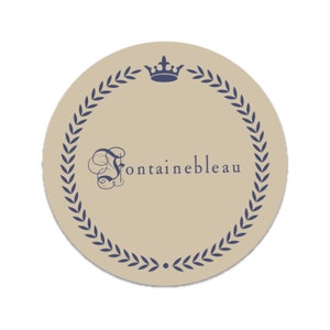 May include: A beige circle with a blue laurel wreath border and a crown at the top. The text "Fontainebleau" is written in a stylized font inside the wreath.