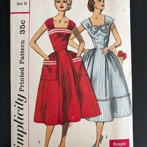 Può includere: Modello di cucito Simplicity vintage, numero 2083, con due modelli di abiti. La copertina mostra illustrazioni degli abiti, uno rosso con finiture e tasche bianche, l'altro a righe blu e bianche. Il modello è per una taglia 16 con un busto di 91 cm.