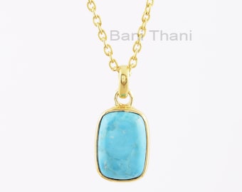 May include: A gold chain necklace with a turquoise pendant. The pendant is rectangular in shape with a smooth, polished surface.