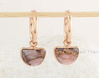May include: Rose gold hoop earrings with a pink and gold stone pendant. The stone has a marbled pattern.