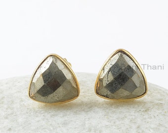 Op de afbeelding: Een paar gouden driehoekige oorbel studs met een grijze pyriet steen in elke oorbel.