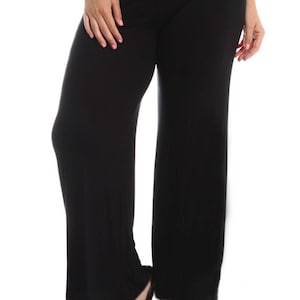 May include: Black wide-leg pants with a wide waistband. The pants are made of a soft, stretchy fabric and have a relaxed fit.