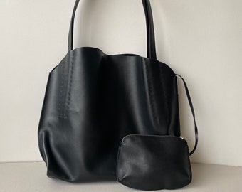 May include: A black tote bag with long handles and a matching small pouch. The tote bag has a wavy top edge and vertical stitching details. The pouch has a zipper closure. Both items are made of a smooth, matte material.