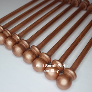 Puede incluir: Un conjunto de diez clavijas de madera de color cobre con extremos redondeados. Las clavijas están dispuestas en forma de abanico, con los extremos redondeados mirando al espectador. Las clavijas miden aproximadamente 25 cm de largo. Visita Scroll Parts en Etsy.