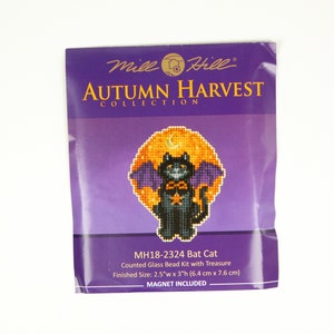 Pode incluir: Um kit de contas de vidro contadas com um gato preto que usa uma capa roxa e uma estrela no peito, em frente a uma lua amarela com uma lua crescente e uma estrela. O kit faz parte da coleção Autumn Harvest e inclui um ímã. O tamanho final é de 6,4 cm de largura por 7,6 cm de altura.