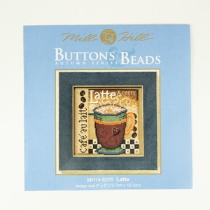 Op de afbeelding: Een kruissteekpatroon voor een latte met de tekst "Cafe au lait" en "Latte & Coffee" op een blauwe achtergrond. De afmeting van het ontwerp is 5 inch bij 5 inch (12,7 cm bij 12,7 cm).