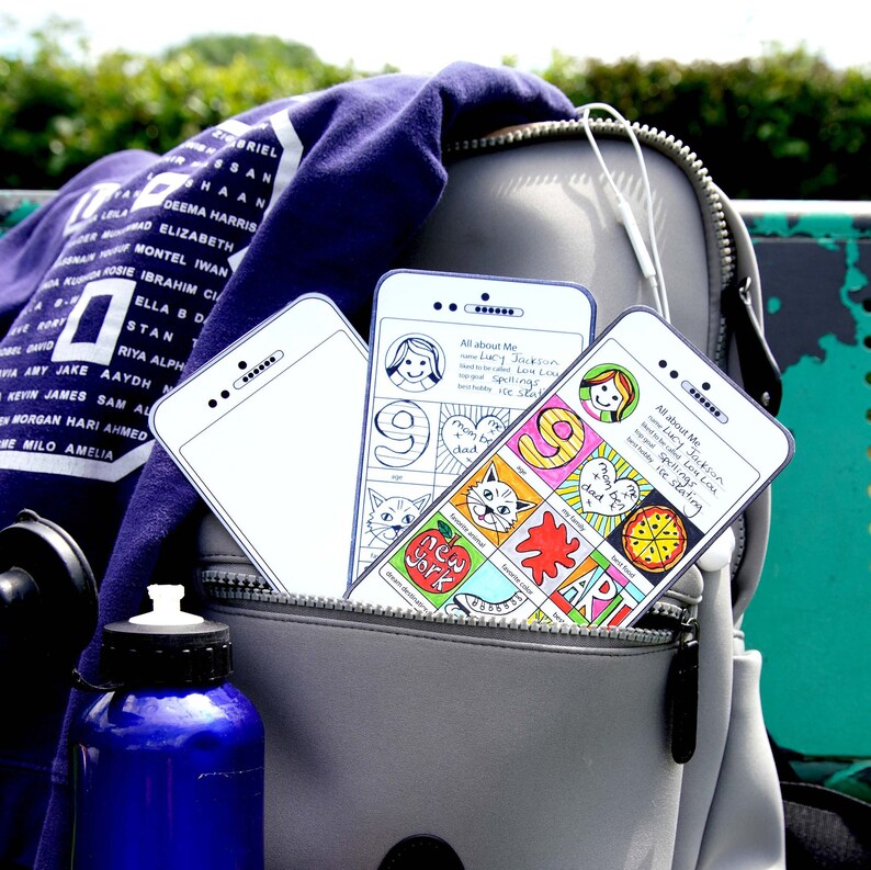 May include: Three colorful phone-shaped cards with a white background and black outlines. The cards have a variety of drawings and text, including "All about Me", "Lucy Jackson", "Spellings", "Ice Skating", "New York", "Art", and "Best Food".