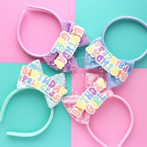 Puede incluir: Cuatro diademas de color pastel con lazos de lentejuelas y las palabras "Birthday Girl", "Birthday Princess" y "Birthday Princess" en letras arco&iacute;ris.