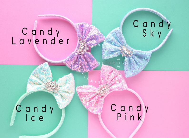 Puede incluir: Cuatro diademas con lazos de diferentes colores. Los lazos est&aacute;n hechos de lentejuelas iridiscentes y tienen un peque&ntilde;o dije de corona en el centro. Las diademas est&aacute;n etiquetadas como "Candy Lavender", "Candy Sky", "Candy Ice" y "Candy Pink".