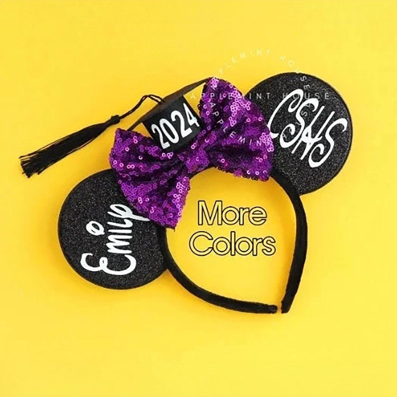 May include: Black mouse ears with a purple sequined bow, a black graduation cap with the year 2024 on it, and a black tassel. The right ear says "Class of 2024" and the left ear says "Emily".