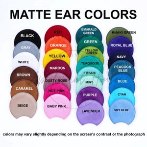 May include: A chart of 20 different colors, each represented by a round, slightly curved, suede-like patch. The colors are arranged in four rows of five patches each. The colors include black, gray, white, brown, caramel, beige, red, orange, yellow, maroon, dusty rose, hot pink, baby pink, emerald green, khaki green, green, yellow green, turquoise, tiffani, mint, purple, lavender, royal blue, navy, peacock blue, blue, cyan, and sky blue. The text "MATTE EAR COLORS" is at the top of the chart. The text "colors may vary slightly depending on the screen's contrast or the photograph" is at the bottom of the chart.
