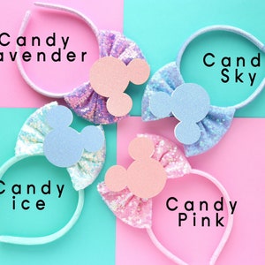 Puede incluir: Cuatro diademas coloridas con un lazo y orejas de Mickey Mouse. Las diademas est&aacute;n etiquetadas como "Candy Lavender", "Candy Sky", "Candy Ice" y "Candy Pink".