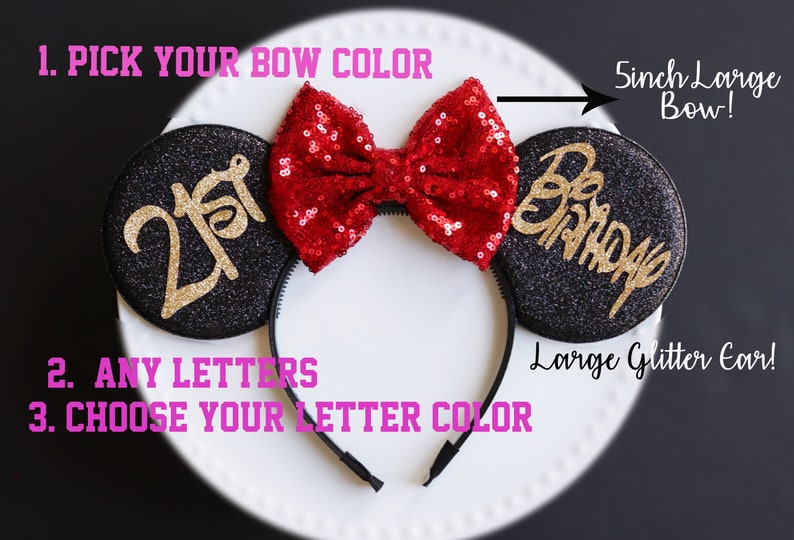 Może przedstawiać: Czarne uszy Minnie Mouse z brokatem i czerwoną kokardą z cekin&oacute;w. Na lewym uchu napis "21st" w złotym brokacie. Na prawym uchu napis "Happy Birthday" w złotym brokacie. Kokarda ma 12,7 cm szerokości.