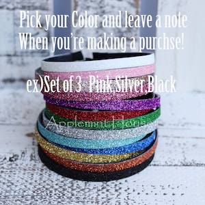 May include: A stack of 10 glitter headbands in various colors, including pink, silver, black, red, green, blue, and gold. The text "ex) Set of 3 Pink, Silver, Black" is visible on the image.