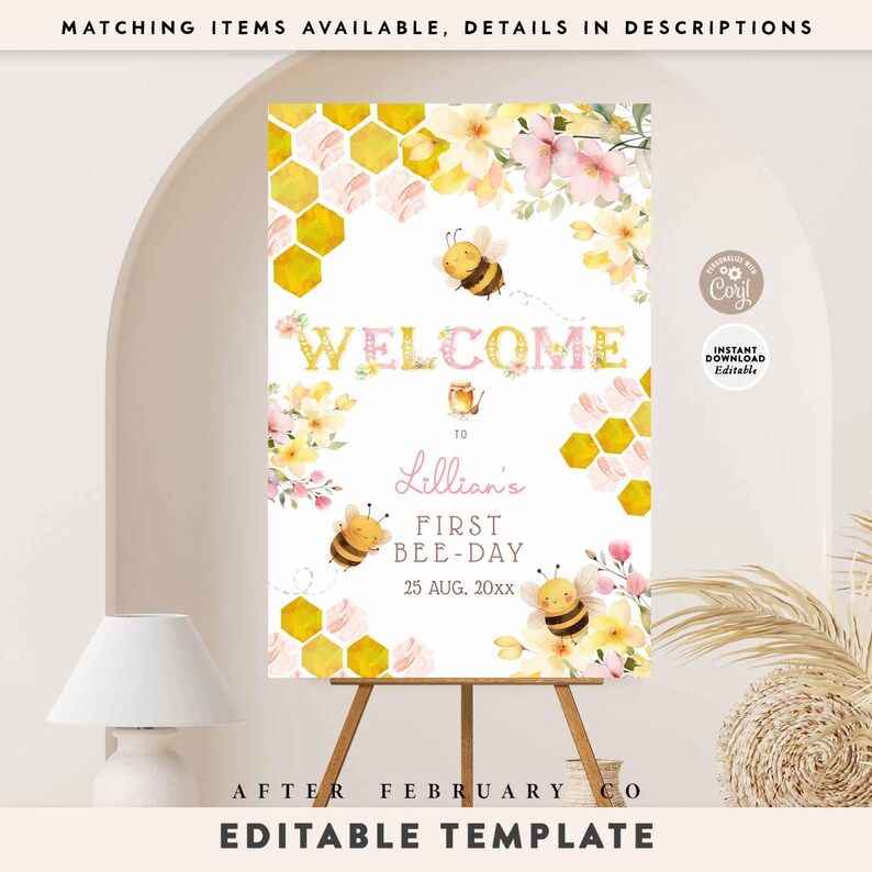 May include: A welcome sign for a first birthday party, featuring a bee theme. The sign includes the text "WELCOME" and "Lillian's FIRST BEE-DAY" with decorative bees, flowers, and honeycomb patterns. The sign is displayed on a wooden easel.
