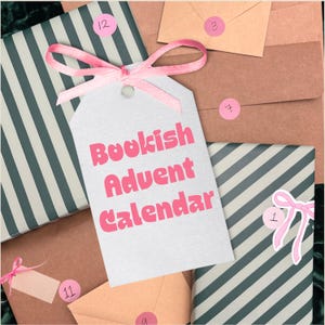 May include: A white gift tag with a pink ribbon bow featuring the text Bookish Advent Calendar in pink letters. The tag is surrounded by wrapped packages with dark green and white diagonal stripes and brown envelopes with pink numbered stickers.