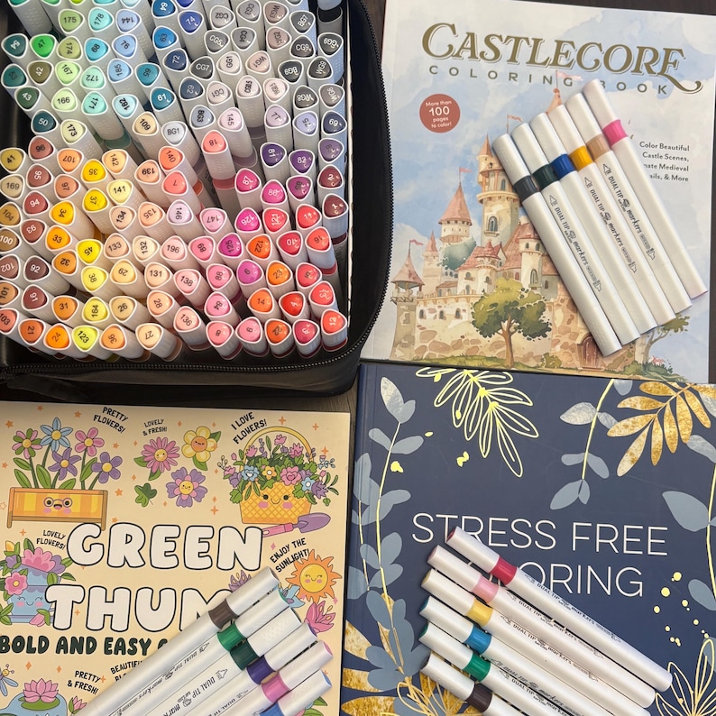 May include: A collection of art supplies including a black carrying case filled with colorful markers, coloring books with floral and castle themes, and sets of dual-tip markers. The coloring books have text that reads "Castlecore Coloring Book" and "Stress Free Coloring".