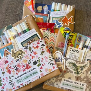 May include: A collection of wrapped packages, each adorned with stickers and containing various items. The packages include coloring books, markers, snacks, and tea. Floral and patterned paper wraps the packages, creating a visually appealing assortment.