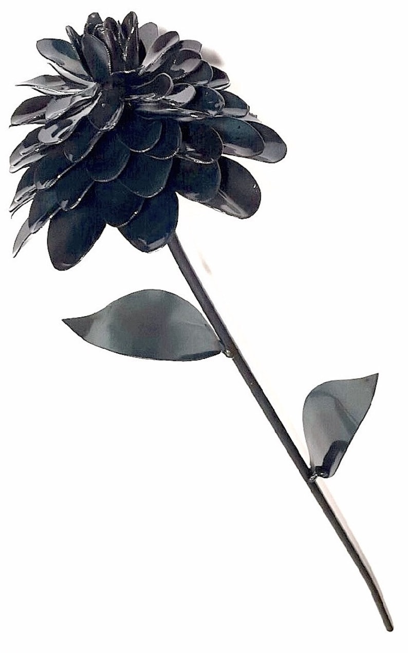 May include: A black metal flower with a single stem and leaves. The flower is made of many overlapping petals, giving it a full and rounded appearance.