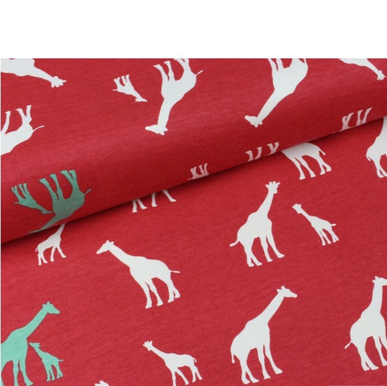 May include: Red fabric with a white giraffe print. The giraffes are in various sizes and positions, some are facing left and some are facing right. The fabric has a textured surface.