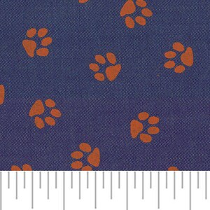 Peut inclure: Un tissu bleu marine avec un motif r&eacute;p&eacute;t&eacute; d'empreintes de pattes orange. Une r&egrave;gle est incluse pour montrer l'&eacute;chelle du tissu.