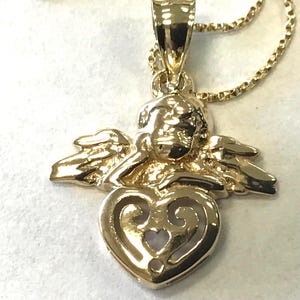 Colgante de ángel en oro amarillo de 10 k sobre cadena de eslabones trenzados de 18" de oro macizo con todas las partes marcadas