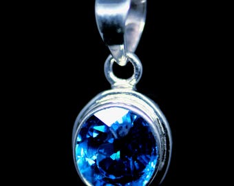 May include: A silver pendant necklace with a round blue gemstone.