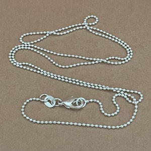 Op de afbeelding: Een zilveren ballenketting met een karabijn sluiting. De ketting is ongeveer 50 cm lang.
