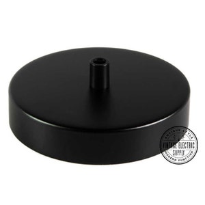 May include: Black metal ceiling rose for pendant light fixtures. The rose has a round base and a central hole for the cord.
