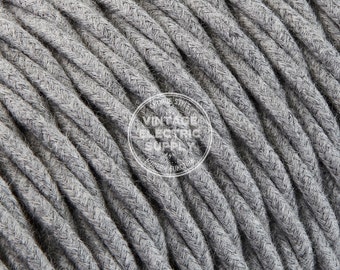 May include: Close-up of gray braided fabric electrical cord. The cord is made of a soft, textured material and has a vintage look.