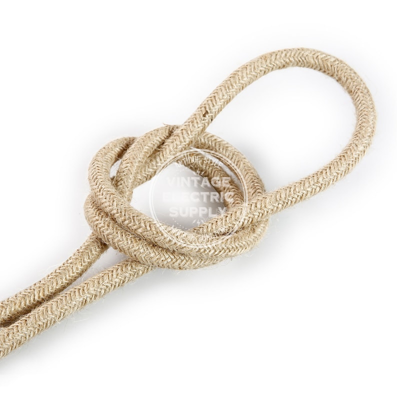 Puede incluir: Primer plano de un cord&oacute;n de algod&oacute;n trenzado de color natural. El cord&oacute;n est&aacute; retorcido en un nudo, mostrando la textura de la tela.