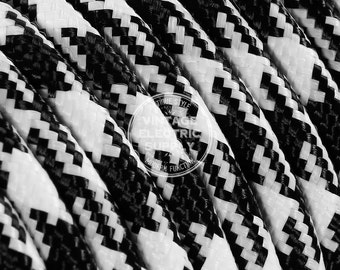 May include: Close-up of black and white checkered electrical cord. The cord is made of braided fabric and has a vintage style.