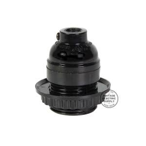 May include: A black lamp socket with a ribbed base and a rounded top. The socket has a threaded interior for a light bulb and is marked with "LISTED" and a UL symbol. A circular sticker with text is visible.