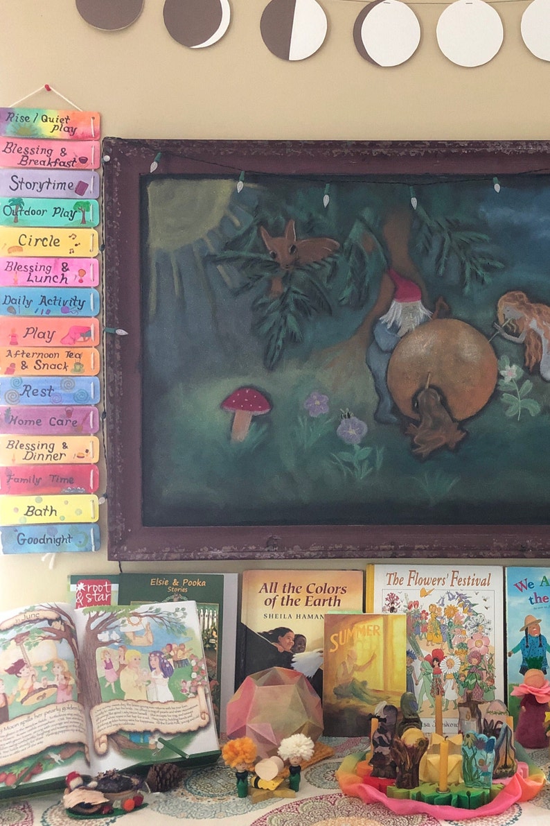 K&ouml;nnte beinhalten: Ein farbenfroher Lernraum mit einer Tafel, auf der eine fantasievolle Illustration eines Zwergs zu sehen ist, der Trommel spielt. Der Raum ist au&szlig;erdem mit verschiedenen B&uuml;chern ausgestattet, darunter "Alle Farben der Erde" und "Das Blumenfest", sowie einem Holzspielzeugset.