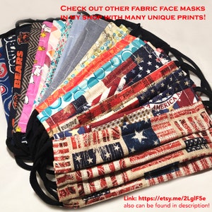 May include: A collection of fabric face masks with various patterns, including an American flag design, team logo, and floral prints. The masks have black elastic ear loops and are folded. Text on the image reads "CHECK OUT OTHER FABRIC FACE MASKS IN MY SHOP WITH MANY UNIQUE PRINTS!"
