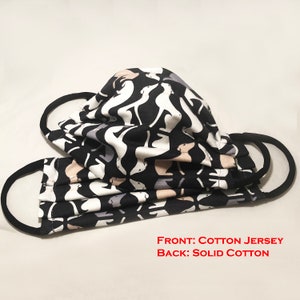 May include: Two face masks with black ear loops. The masks are made of cotton jersey and solid cotton. The front of the masks have a repeating pattern of white, gray, and tan dog silhouettes on a black background.