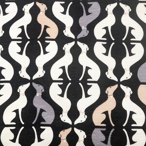 May include: A repeating pattern of stylized dog silhouettes in white, gray, and tan against a black background. Each dog is wearing a collar. The design is symmetrical and creates a visually interesting textile pattern.
