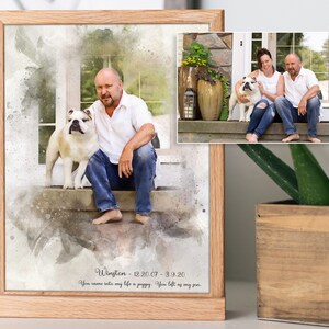 May include: A framed watercolor painting of a man and his dog. The painting is in shades of gray and brown. The man is sitting on a step with his dog beside him. The text below the painting reads "Wington - 12.20.07 - 3.9.20 You came into my life a puppy. You left as my son."