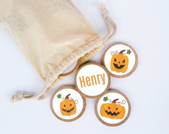 May include: A set of five wooden pumpkin-themed game pieces, including one with the name "Henry" printed on it. The pieces are in a small white canvas bag with a drawstring.