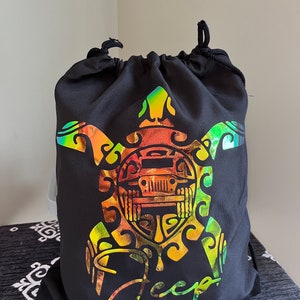 May include: Black drawstring bag with a holographic design of a turtle with a Jeep logo inside. The word "Jeep" is written in a holographic font below the turtle.